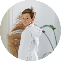 Chłopiec w albie komunijnej z kapturem i  złotymi detalami