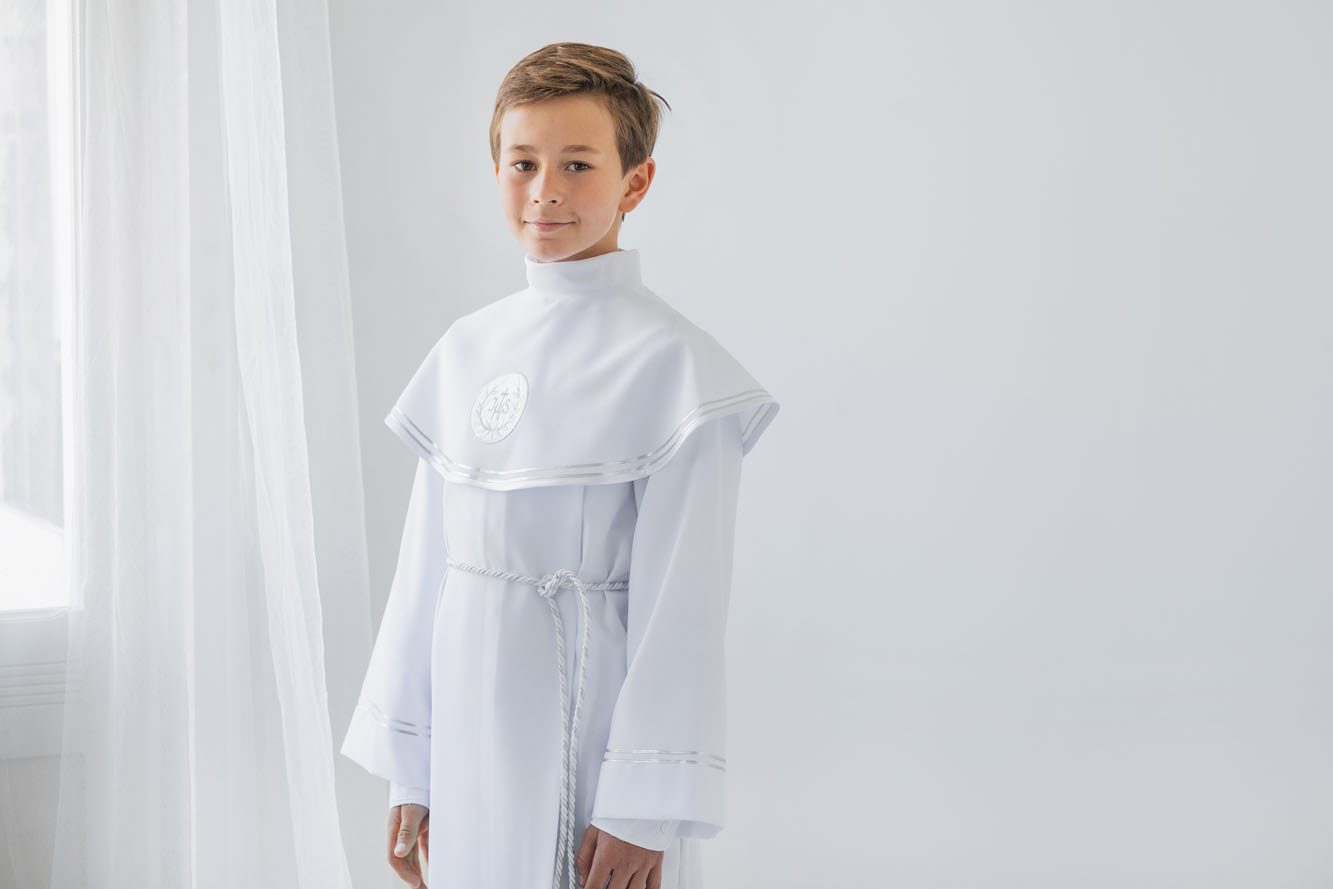 Chłopiec w albie komunijnej z pelerynką i srebrnymi zdobieniami