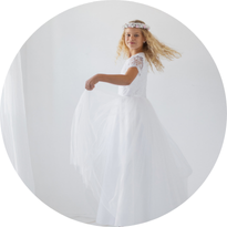 Dziewczynka w sukience komunijnej z rozłożystą spódnicą z tiulu