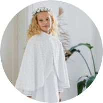 Dziewczynka w albie i ciepłej pelerynce komunijnej